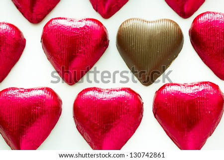 Heart shape chocolate candies wrapped in red foil for Valentine\'s Day.