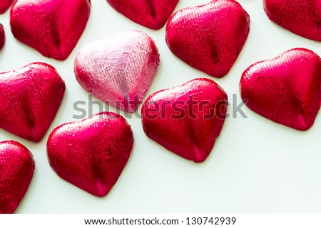 Heart shape chocolate candies wrapped in red foil for Valentine\'s Day.
