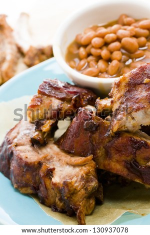 Baby back ribs on the plate with baked beand.
