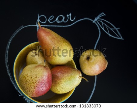 Ripe pear on black background. The cultivation of the pear in cool temperate climates extends to the remotest antiquity, and there is evidence of its use as a food since prehistoric times.