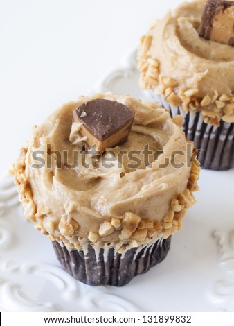 Gourmet peanut butter cups cupcake on white background.
