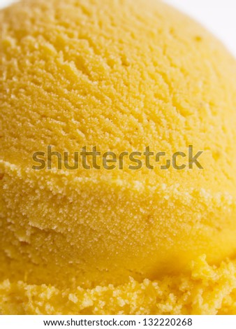 Scoop of gourmet pumpkin gelato in cake cone on white background.