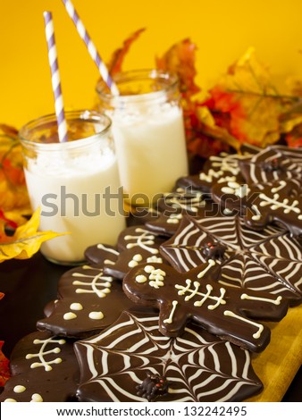 Halloween gourmet cookies with holiday decor orange background.