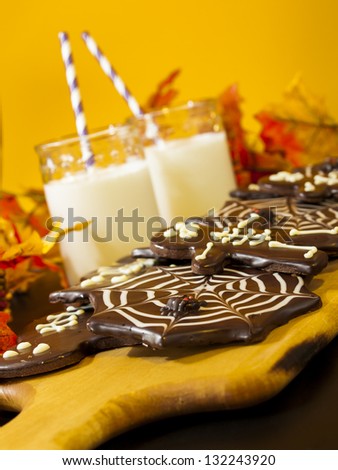 Halloween gourmet cookies with holiday decor orange background.