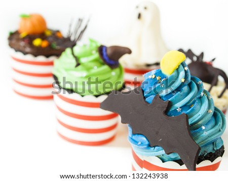 Halloween gourmet cupcakes with holiday decor on white background.