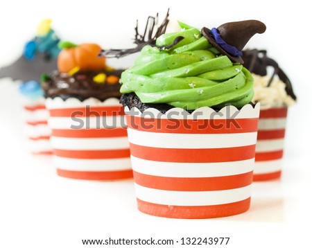 Halloween gourmet cupcakes with holiday decor on white background.