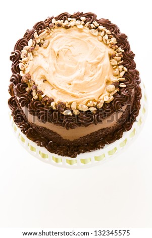 Peanut butter mousse cake with two layers of chocolate cake, filled and topped with peanut butter mousse and covered in chocolate buttercream.