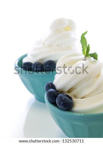 Cup of soft-serve frozen yogurt on white background.