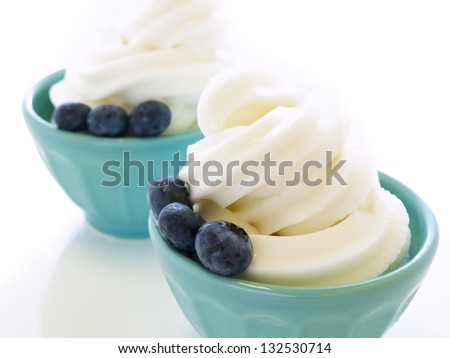 Cup of soft-serve frozen yogurt on white background.