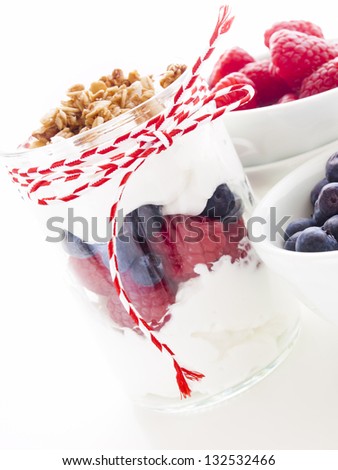 Delicious fruit, greek yogurt and granola parfaits on white background