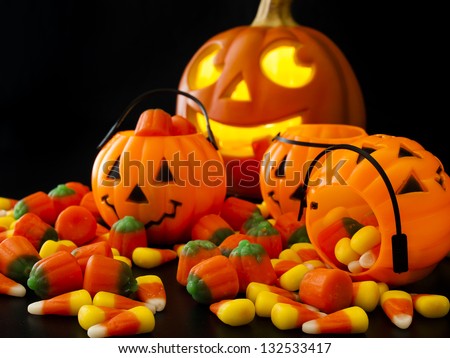 Halloween candies spilled on black background.