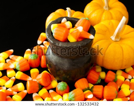 Halloween candies spilled on black background.