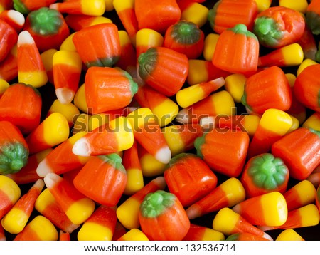 Halloween candy corn and pumpkin candies on black background.