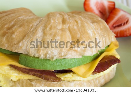 Croissant breakfast sandwich with orange juice served for breakfast.