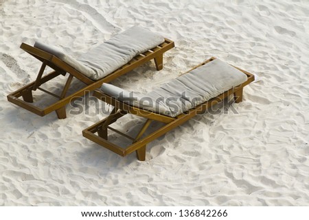 Two pool chairs on the beach of the Caribbean Sea.