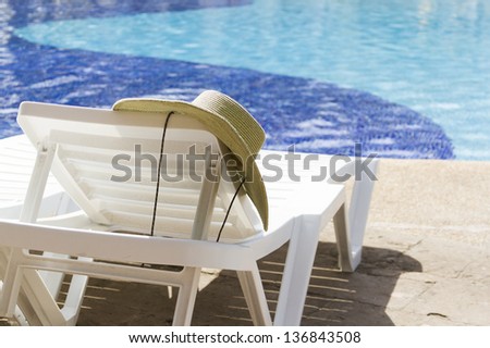 White plastic pool chairs at the swimming pool.