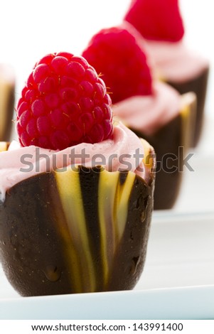 Small chocolate reaspherry tulip cups at dessert bar.