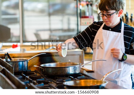 Kids learning how to cook in a cooking class.
