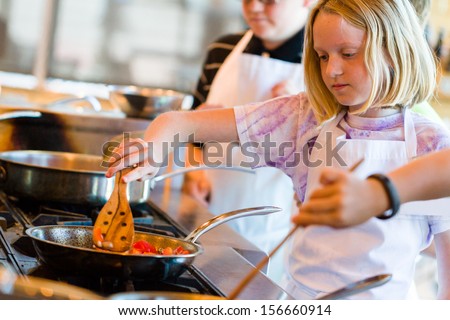 Kids learning how to cook in a cooking class.