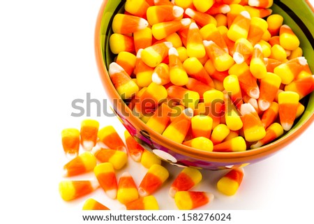Candy corn cadnies in Halloween bowl on a white background.