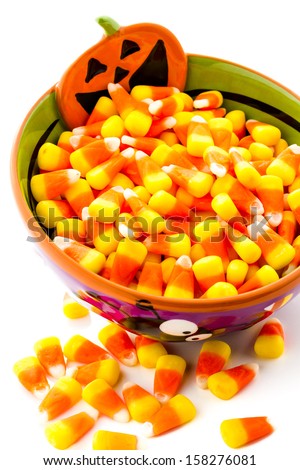 Candy corn cadnies in Halloween bowl on a white background.
