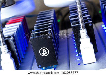 Bitcoin mining USB devices in a row with small fans.