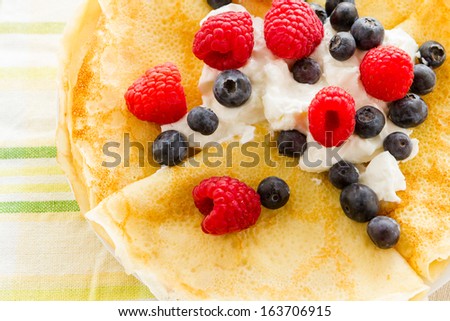 Homemade crepes with fresh raspberries and blueberries.