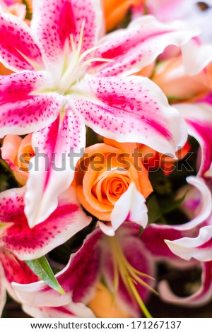 Wedding bouquet with pink lilies and orange roses.