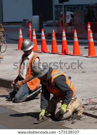 Denver, Colorado-April 9, 2011: Road construction worker on new concrete road in downtown Denver, Colorado.