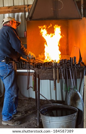 A blacksmith working at an old iron forge.