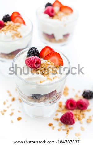 Breakfast parfait made from Greek yogurt and granola topped with fresh berries.
