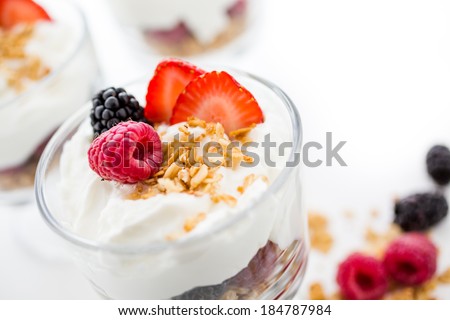 Breakfast parfait made from Greek yogurt and granola topped with fresh berries.