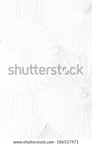 White paper fan in shape of pinwheel on a white background.