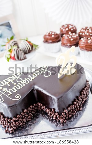 Celebrating wedding anniversary with heart shape chocolate cake.