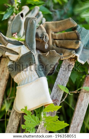 Fence decorated with old work gloves.