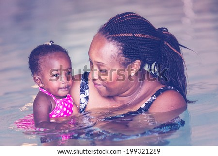 Infant swimming lessons in indoor pool.