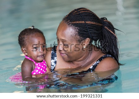 Infant swimming lessons in indoor pool.