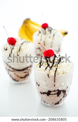Gourmet cold Banana split chocolate drink garnished with dark chocolate and cherry.