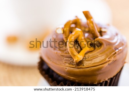 Caramel crunch chocolate cupcake with caramel frosting topped with seasalt and pretzels.