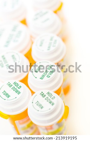 Prescription pills in yellow bottles on a white background.