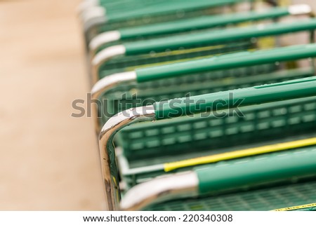 Large green shopping cart in a row.