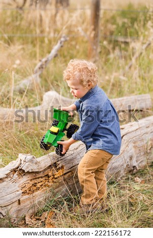 Cute toddler enjoying weekend in open space park in early Autumn.