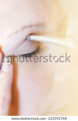 Makeup artist applying make up to the brides face.