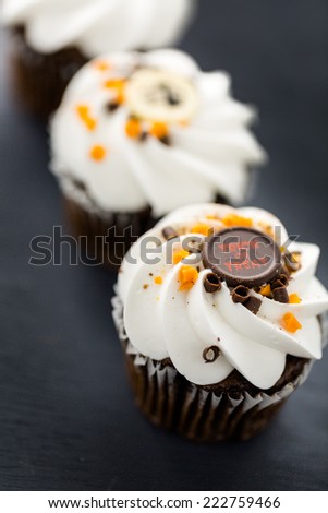 Chocolate Halloween cupcakes with white buttercreme icing and chocolate shavings on top.