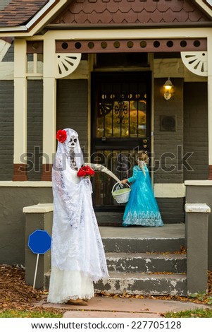 Trick or treating in costumes on Halloween night.