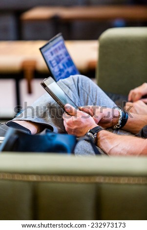 People reading on tablets while waiting for train.