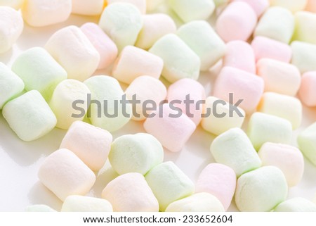 Small round multicolor marshmallows on a white backgrouns.