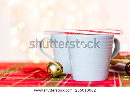 Hot chocolate garnished with small white marshmallows and pepperming stirrer.