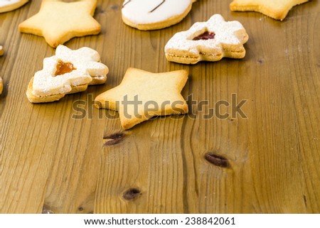 Sugar cookies in shape of snowman, stars, and christmas tree on wood table.