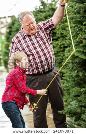 Family selecting a tree for Christmas at the Christmas tree farm.